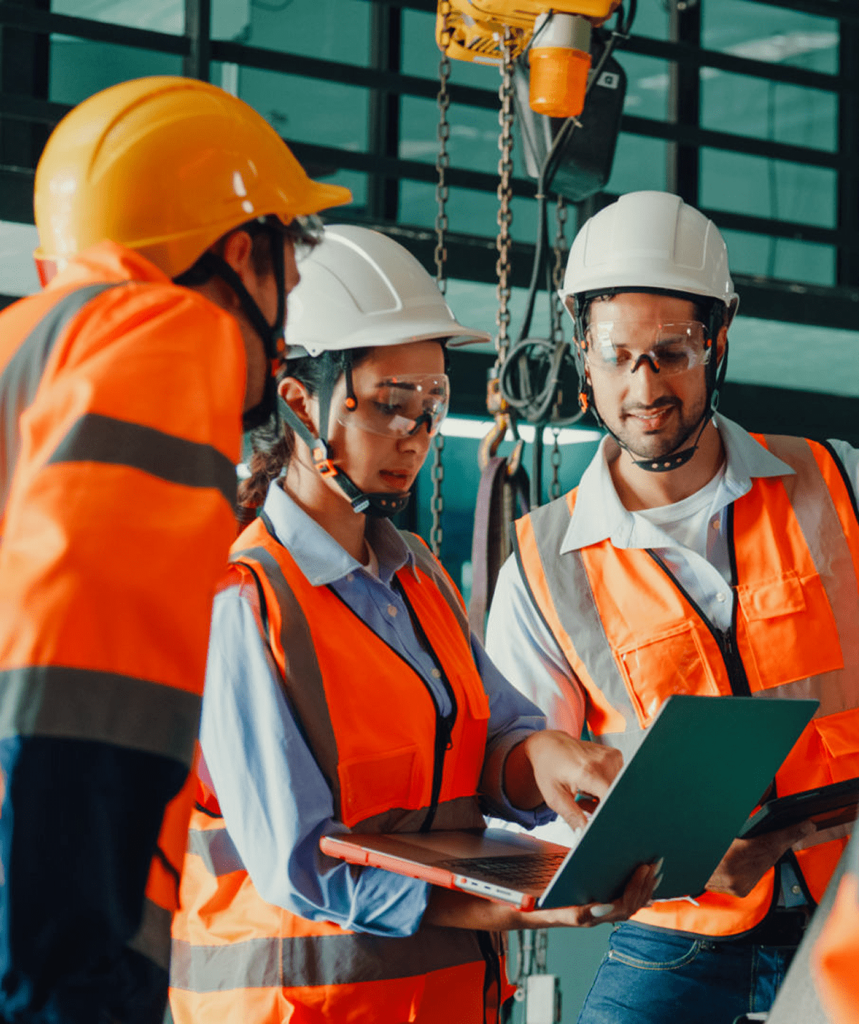 Construction workers discussing project on laptop.