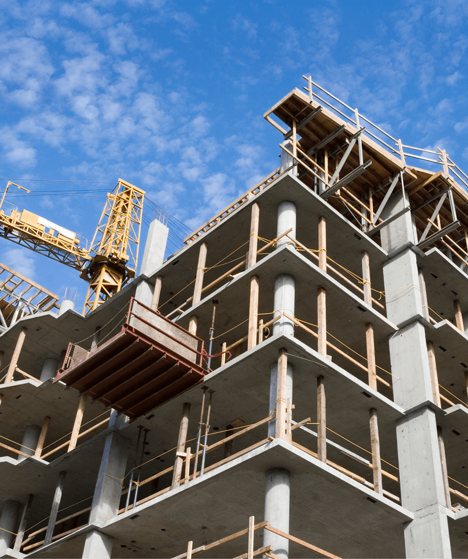 Building under construction with crane, blue sky.